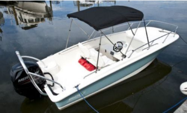Picture of repaired canvas Bimini top on a Boston Whaler super sport, tied to the dock in Miami Florida.