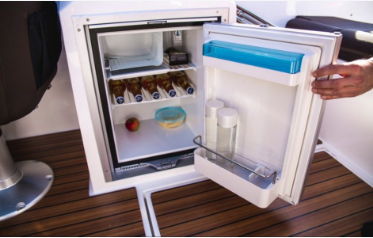 Picture of a mini boat fridge and freezer stocked with beer and water.