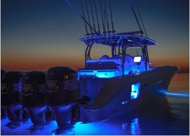 Picture of a center console fishing boat with blue LED deck light installed, glowing at night as the sun sets in Florida. 