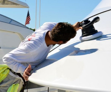 Professional detailer buffing and polishing boat fiberglass.