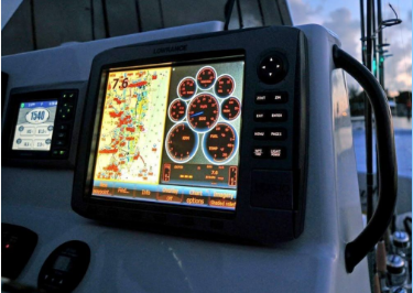 Picture of the dash of a fishing boat with a variety of digital displays showing engine and water information.