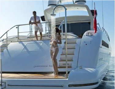 Picture of a woman showering on swim platform of a large yacht with an integrated shower system.